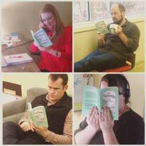 Multiple Infomedia employees reading the same book