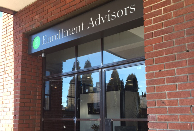 The front of a building with the sign "Enrollment Advisors".