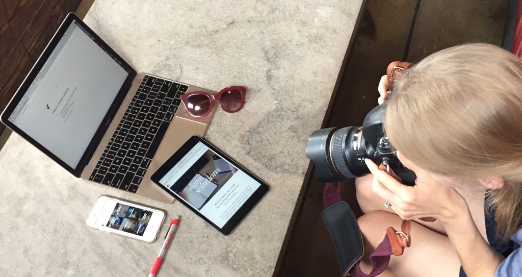woman photographer takes photo of a laptop, sunglasses, ipad, iphone, and Infomedia pen
