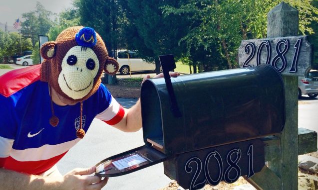 Man with chimpanzee mask opening a mailbox