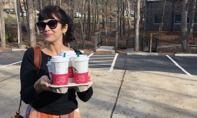 Carrie Rollwagen stands in the parking lot of Infomedia with four cups of Starbucks coffee to treat her coworkers