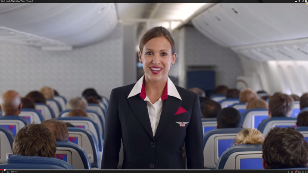 A woman flight attendant talking to the camera