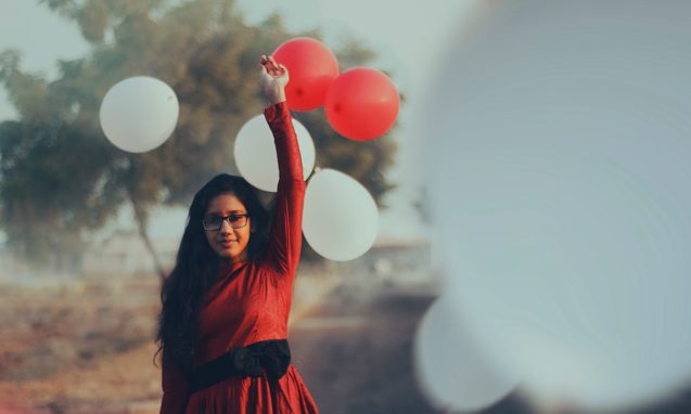 girl holding balloons