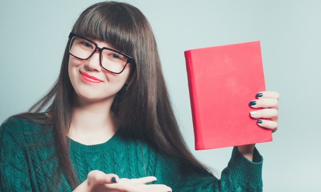 girl wearing glasses holding a red book