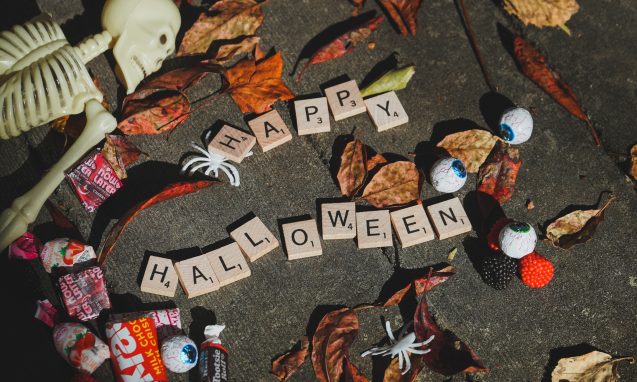 scrabble tiles spelling out "halloween" surrounded by candy