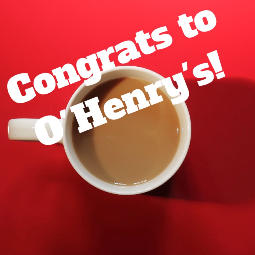 A coffee mug on a red table with the words "Congrats to O'Henry's!" over the image