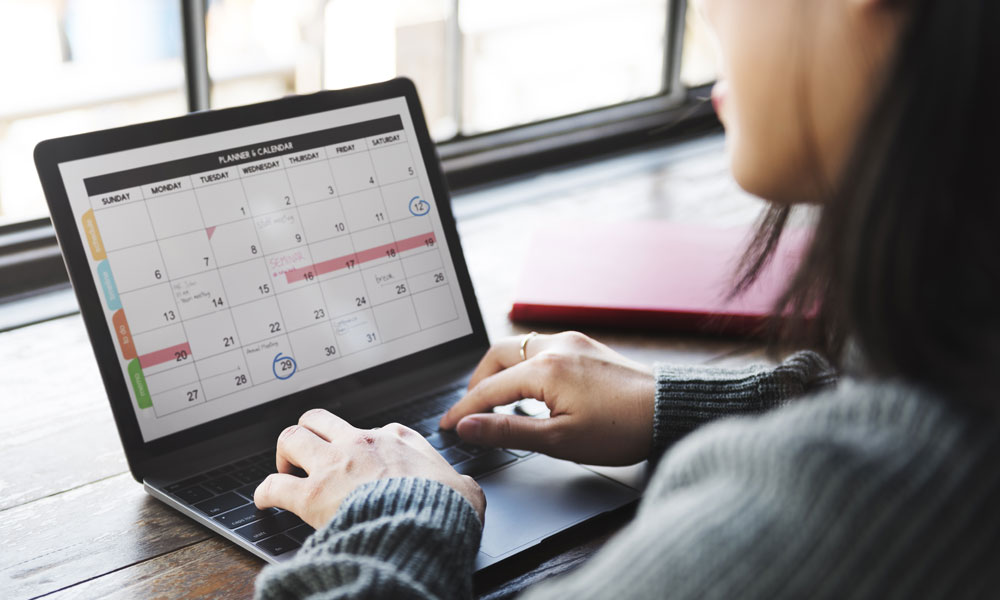 woman works on a calendar on her laptop