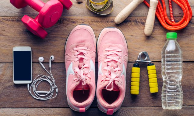 laid out exercise equipment like tennis shoes, weights, and earbuds